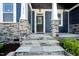 Charming front porch with stone pillars and a dark front door at 1813 Lost Creek Ct, Apex, NC 27539