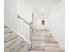 Bright hallway with light wood floors, white walls, and a staircase leading to the upper level at 1813 Lost Creek Ct, Apex, NC 27539