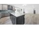 Open kitchen design with a large dark blue island and white countertops, flowing into an open living area with fireplace at 1813 Lost Creek Ct, Apex, NC 27539