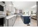 Modern kitchen features stainless steel appliances, gray cabinets, a blue tiled backsplash, and a central island at 1813 Lost Creek Ct, Apex, NC 27539