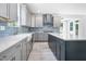A kitchen with white countertops, blue backsplash, and a central island leads to an open dining space at 1813 Lost Creek Ct, Apex, NC 27539