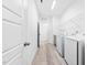 Bright laundry room with a new washer and dryer, shelving and tile floor at 1813 Lost Creek Ct, Apex, NC 27539