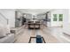 Open concept living room and kitchen with hardwood floors, gray cabinets, and lots of natural light at 1813 Lost Creek Ct, Apex, NC 27539