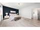 Primary bedroom with a dark accent wall, hardwood floors, and natural light, designed for relaxation at 1813 Lost Creek Ct, Apex, NC 27539