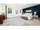 Stylish primary bedroom boasts a blue accent wall, hardwood floors, and large windows with natural light at 1813 Lost Creek Ct, Apex, NC 27539