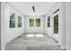 A sunroom features light wood floors, white walls, several windows and a door to the outside at 1813 Lost Creek Ct, Apex, NC 27539