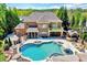 Aerial view of a brick house featuring an in-ground pool, basketball court, outdoor kitchen, and lush landscaping at 187 Stoney Creek Way, Chapel Hill, NC 27517