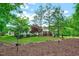 Spacious backyard showcasing lush green lawn, mature trees, garden beds, and backyard pool at 187 Stoney Creek Way, Chapel Hill, NC 27517
