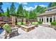 Inviting backyard patio with stone fire pit, wood storage, and comfortable seating area at 187 Stoney Creek Way, Chapel Hill, NC 27517
