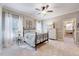 Bright bedroom with a wrought iron bed, neutral walls, ceiling fan, and adjoining closet at 187 Stoney Creek Way, Chapel Hill, NC 27517