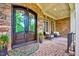 Stone front porch with decorative glass front door and seating area at 187 Stoney Creek Way, Chapel Hill, NC 27517