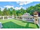 Rooftop deck featuring artificial turf, white railings, and views of the landscaped backyard and trees at 187 Stoney Creek Way, Chapel Hill, NC 27517