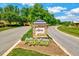 Community entrance sign for Legacy, featuring stone construction, landscaping, and well-maintained roads at 187 Stoney Creek Way, Chapel Hill, NC 27517