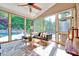 Relaxing sunroom featuring large windows offering views of the pool and backyard, ceiling fan and stylish furniture at 187 Stoney Creek Way, Chapel Hill, NC 27517
