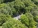 An aerial shot showcases a house immersed in a dense canopy of green trees at 2001 Lovdal Dr, Raleigh, NC 27613