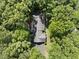 Aerial view of a home with a dark roof nestled among lush green trees at 2001 Lovdal Dr, Raleigh, NC 27613