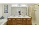 Well-lit bathroom with double sinks, shower, bathtub, and wood cabinets at 2001 Lovdal Dr, Raleigh, NC 27613