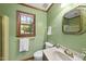 Bathroom with green walls features a single sink vanity and a window offering natural light and scenic views at 2001 Lovdal Dr, Raleigh, NC 27613