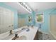 Bright bathroom with double vanity, large mirror, and patterned floor, complemented by blue wall paint at 2001 Lovdal Dr, Raleigh, NC 27613