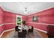 Elegant dining room with a round table, rich red walls, and a classic chandelier at 2001 Lovdal Dr, Raleigh, NC 27613