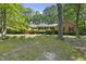 Charming brick ranch home featuring mature trees and manicured landscaping at 2001 Lovdal Dr, Raleigh, NC 27613