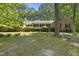 Charming single-story brick home surrounded by lush greenery and a well-maintained lawn at 2001 Lovdal Dr, Raleigh, NC 27613