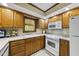 Traditional kitchen with wood cabinets, white appliances, and a cozy, functional design at 2001 Lovdal Dr, Raleigh, NC 27613