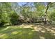 Ranch home with brick exterior, and shaded back yard with a small patio at 2001 Lovdal Dr, Raleigh, NC 27613