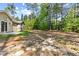 Backyard with grassy areas, mature trees, and a concrete patio at 217 Griffis Dr, Stem, NC 27581