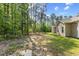 Large backyard view of home with trees and grass at 217 Griffis Dr, Stem, NC 27581