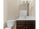 Bathroom vanity with dark cabinets, white countertops, mirror, sink, and toilet at 217 Griffis Dr, Stem, NC 27581