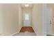 Hallway with hardwood floors transitions to carpet, leading to an ornate front door with glass details at 217 Griffis Dr, Stem, NC 27581