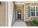Close-up of a home's front entryway showing the front door with decorative glass and stone wall accents at 217 Griffis Dr, Stem, NC 27581