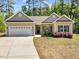 Charming single Gathering home with lush lawn and welcoming covered front entrance with stone accents and white garage door at 217 Griffis Dr, Stem, NC 27581