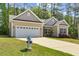 Charming home with white garage door, stone accents and a manicured lawn, complemented by a blue fire hydrant at 217 Griffis Dr, Stem, NC 27581