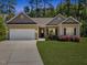 Charming single Gathering home with lush lawn and welcoming covered front entrance with stone accents and white garage door at 217 Griffis Dr, Stem, NC 27581