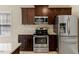 Bright kitchen with dark cabinets, granite countertops and stainless steel appliances at 217 Griffis Dr, Stem, NC 27581