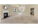 Bright living space with fireplace, ceiling fan, plush carpeting, and open sightlines to the kitchen at 217 Griffis Dr, Stem, NC 27581