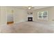 Living area featuring a fireplace, neutral carpet, ceiling fan, and access to other rooms via doorways at 217 Griffis Dr, Stem, NC 27581