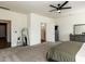 View of primary bedroom featuring carpeted floors, ceiling fan, closet, and full-length mirror at 218 E Tecoma Ln, Clayton, NC 27520