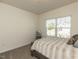 Cozy bedroom featuring a window with blinds and neutral walls and carpet at 218 E Tecoma Ln, Clayton, NC 27520