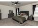 Spacious bedroom featuring a ceiling fan, carpet, and dresser with a mirror for ample storage at 218 E Tecoma Ln, Clayton, NC 27520