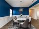 Modern dining room showcasing elegant lighting, a marble top table, stylish chairs, and bold blue walls at 218 E Tecoma Ln, Clayton, NC 27520