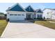 Charming single Gathering home showcasing blue and white color palette, a two car garage, and long concrete driveway at 218 E Tecoma Ln, Clayton, NC 27520