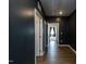 Hallway featuring dark grey walls and dark wood floors and white doors at 218 E Tecoma Ln, Clayton, NC 27520
