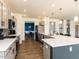 Open concept kitchen featuring stainless steel appliances, gray cabinets, pendant lighting, and quartz countertops at 218 E Tecoma Ln, Clayton, NC 27520
