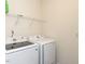 Bright laundry room featuring a modern, front-loading washer and dryer with overhead shelving at 218 E Tecoma Ln, Clayton, NC 27520