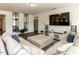 Spacious living room featuring comfortable seating, a modern media center, neutral walls, and luxury vinyl flooring at 218 E Tecoma Ln, Clayton, NC 27520