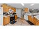 Well-equipped kitchen featuring wood cabinets, updated appliances, and tile flooring at 228 Honeywell Way, Fuquay Varina, NC 27526