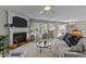 Cozy living room featuring a fireplace, plush seating, and large windows for ample natural light at 228 Honeywell Way, Fuquay Varina, NC 27526